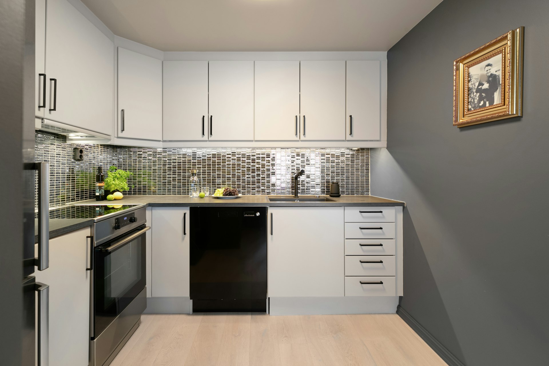 A kitchen with white cabinets and black appliances